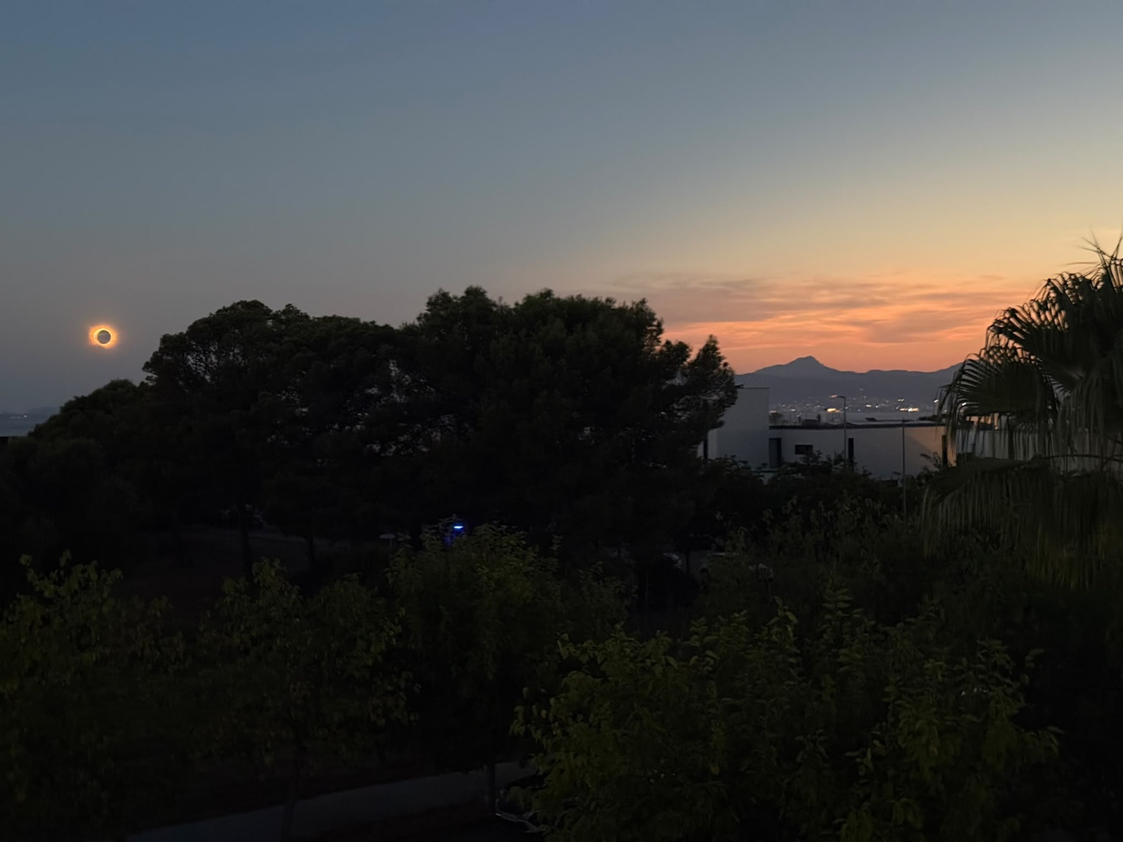 Totale Sonnenfinsternis als glühender Ring links über der Bucht von Palma, dahinter der Puig de Galatzó im Abendrot