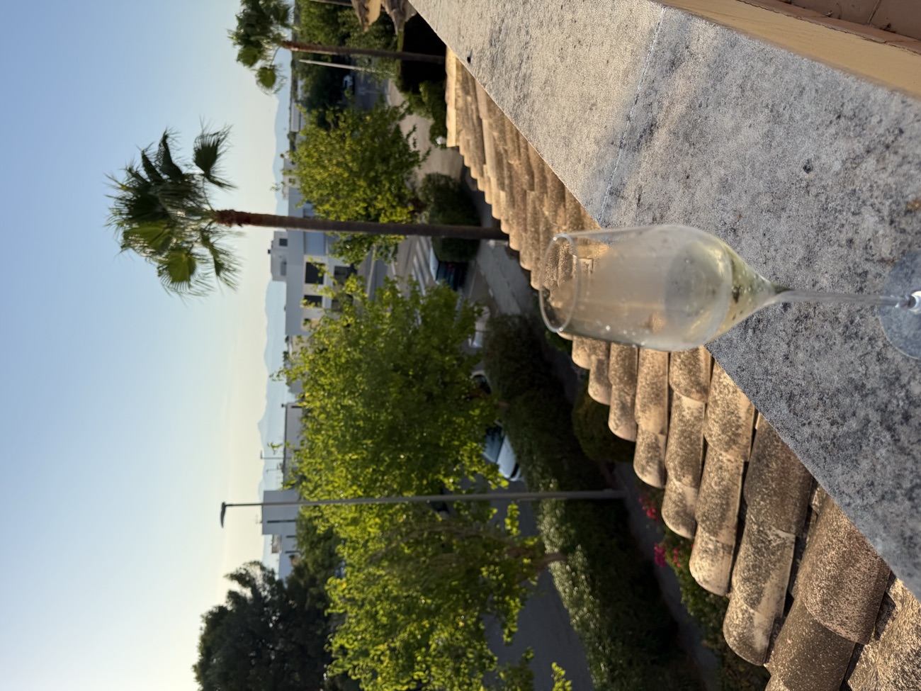 Glas Champagner auf der Terrassenmauer mit Blick über die Bucht von Palma vor Beginn der Sonnenfinsternis